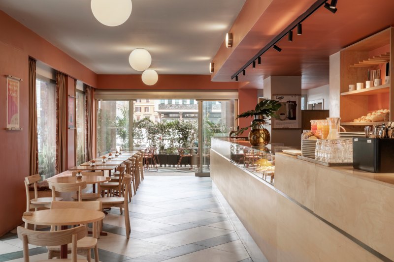 Sala colazioni dell’hotel con disposizione tavoli e banco bar moderno, ideale per business e leisure a Roma - Moderno Hotel Roma, BZAR hotels a Roma