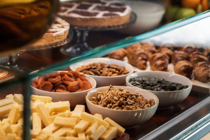 Dettaglio del buffet colazione con formaggi, frutta secca, dolci e prodotti freschi nel bakery hotel a Roma - Moderno Hotel Roma, BZAR hotels a Roma